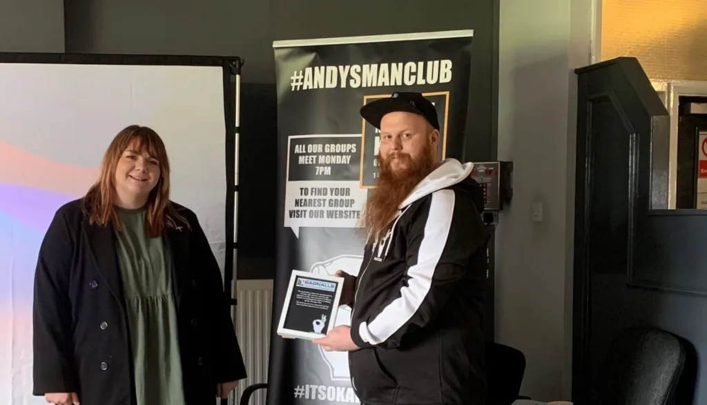 A Bagnalls Team Member Stands With A Member Of The Andy's Man Club Team Who Holds A Plaque