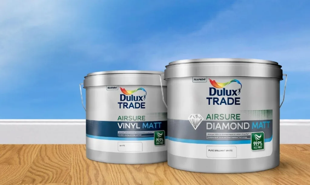 A Tin Of Dulux Trade Airsure Diamond Matt Paint Sits Beside A Tin Of Dulux Trade Airsure Vinyl Matt Paint