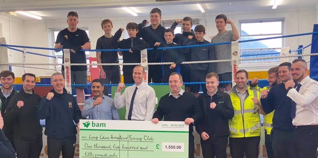 A Number Of People Stand Around A Boxing Ring Holding A Large Cheque For One Thousand Five Hundred And Fifty Pounds