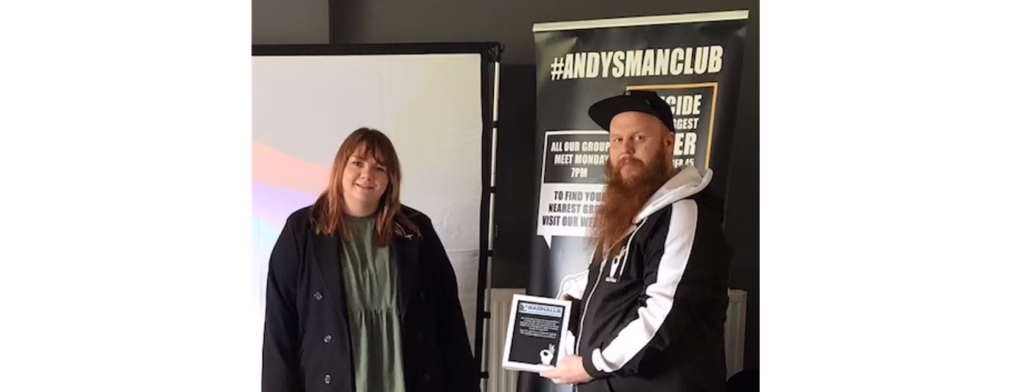 A Bagnalls Team Member Stands With A Member Of The Andy's Man Club Team Who Holds A Plaque