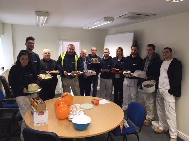 Eleven Member Of The Bagnalls Team Stand Together Holding Cakes