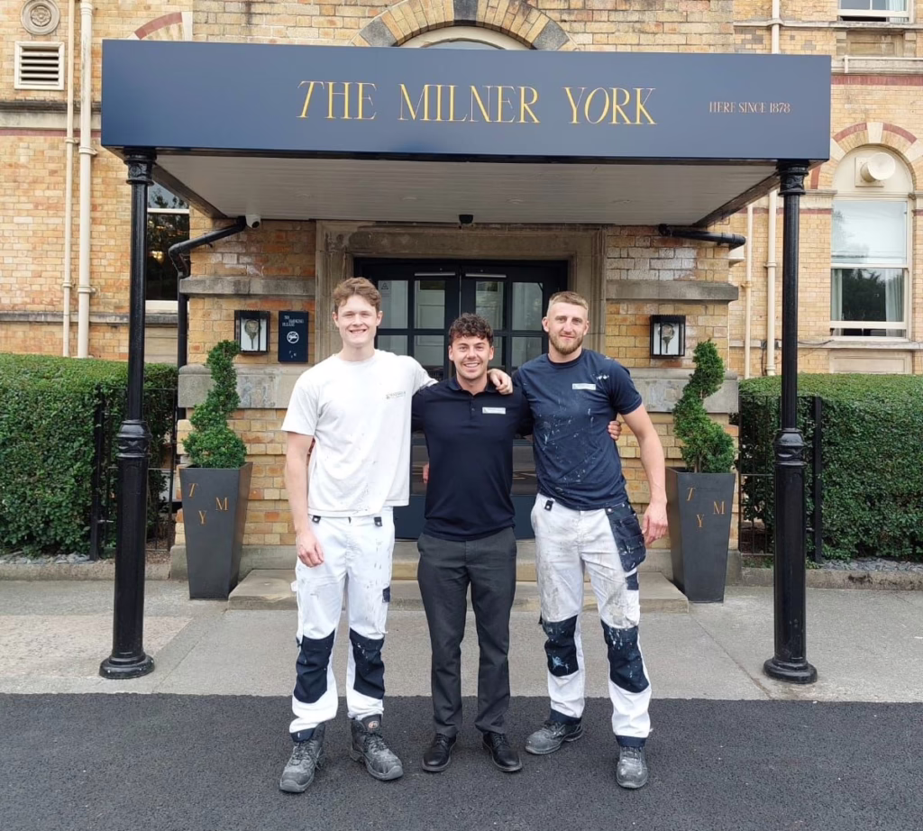 Three men in front of building.